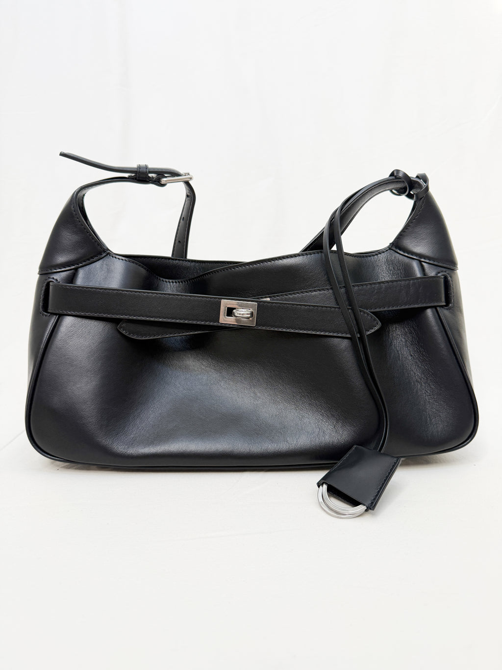 Black leather handbag with a strap on a white background