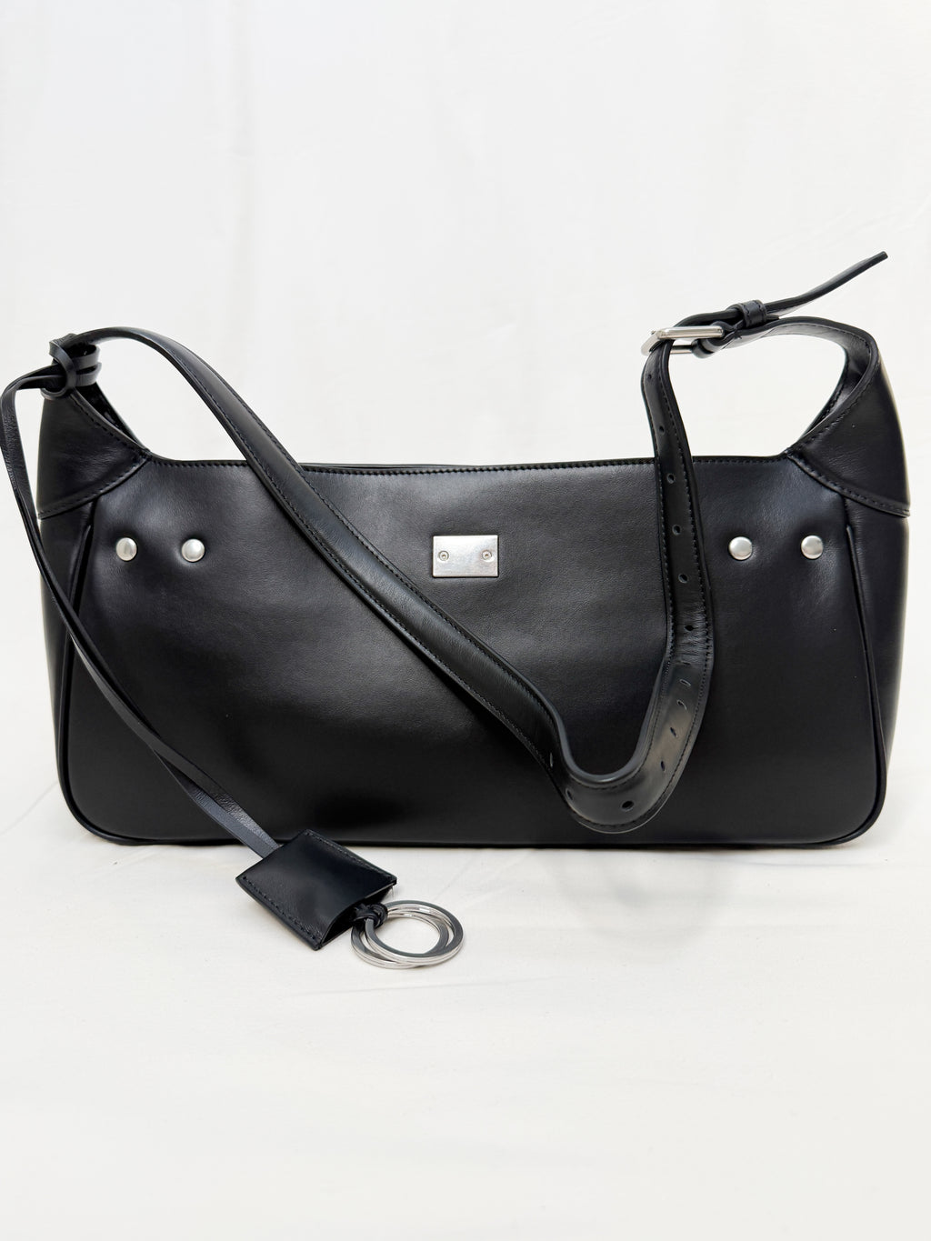 Black leather handbag with a shoulder strap on a white background