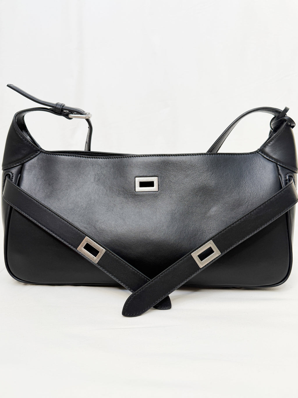 Black leather handbag with a strap on a white background