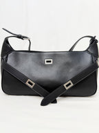 Black leather handbag with a strap on a white background