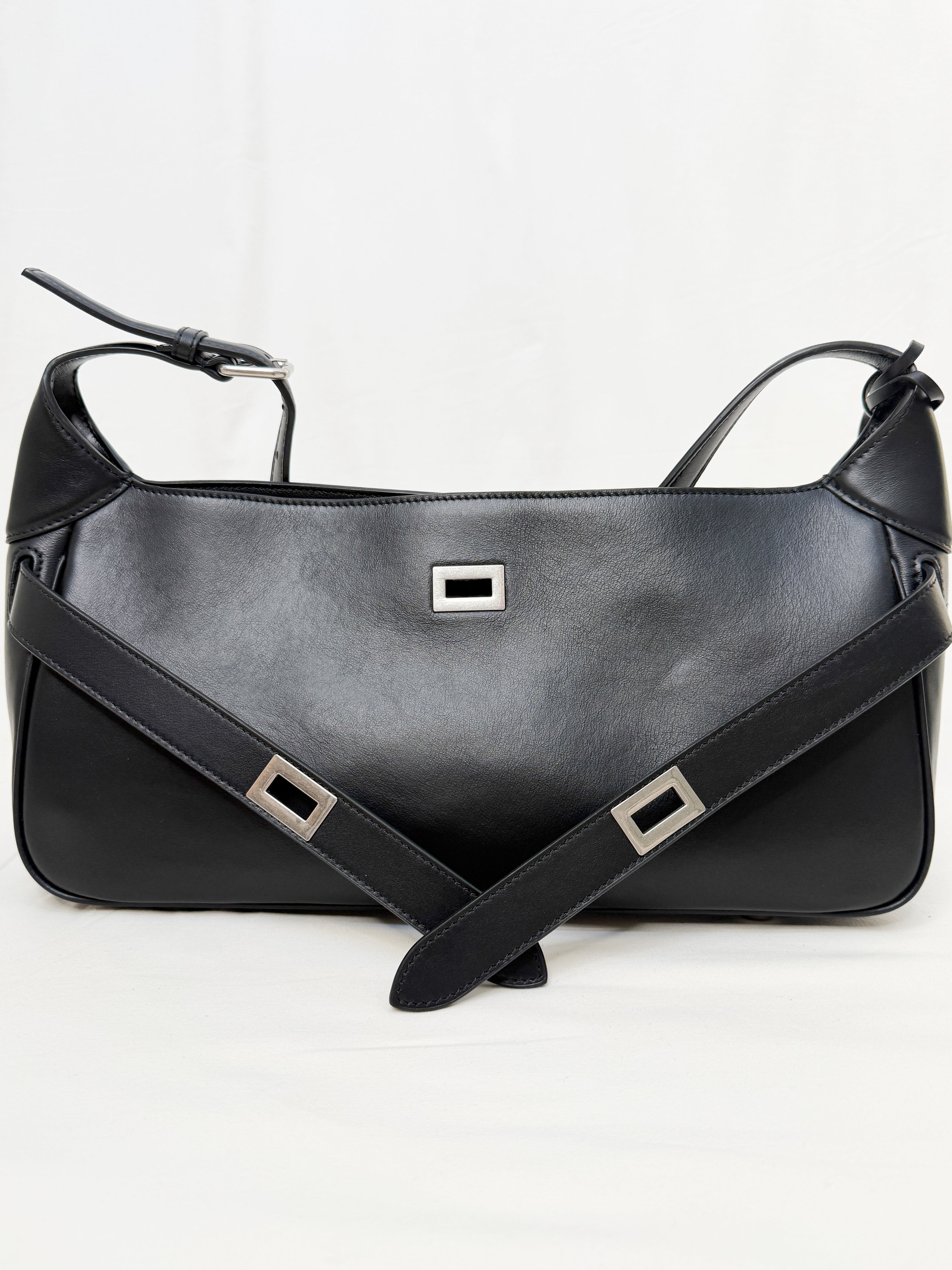 Black leather handbag with a strap on a white background