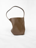 Brown leather handbag with a handle on a white background