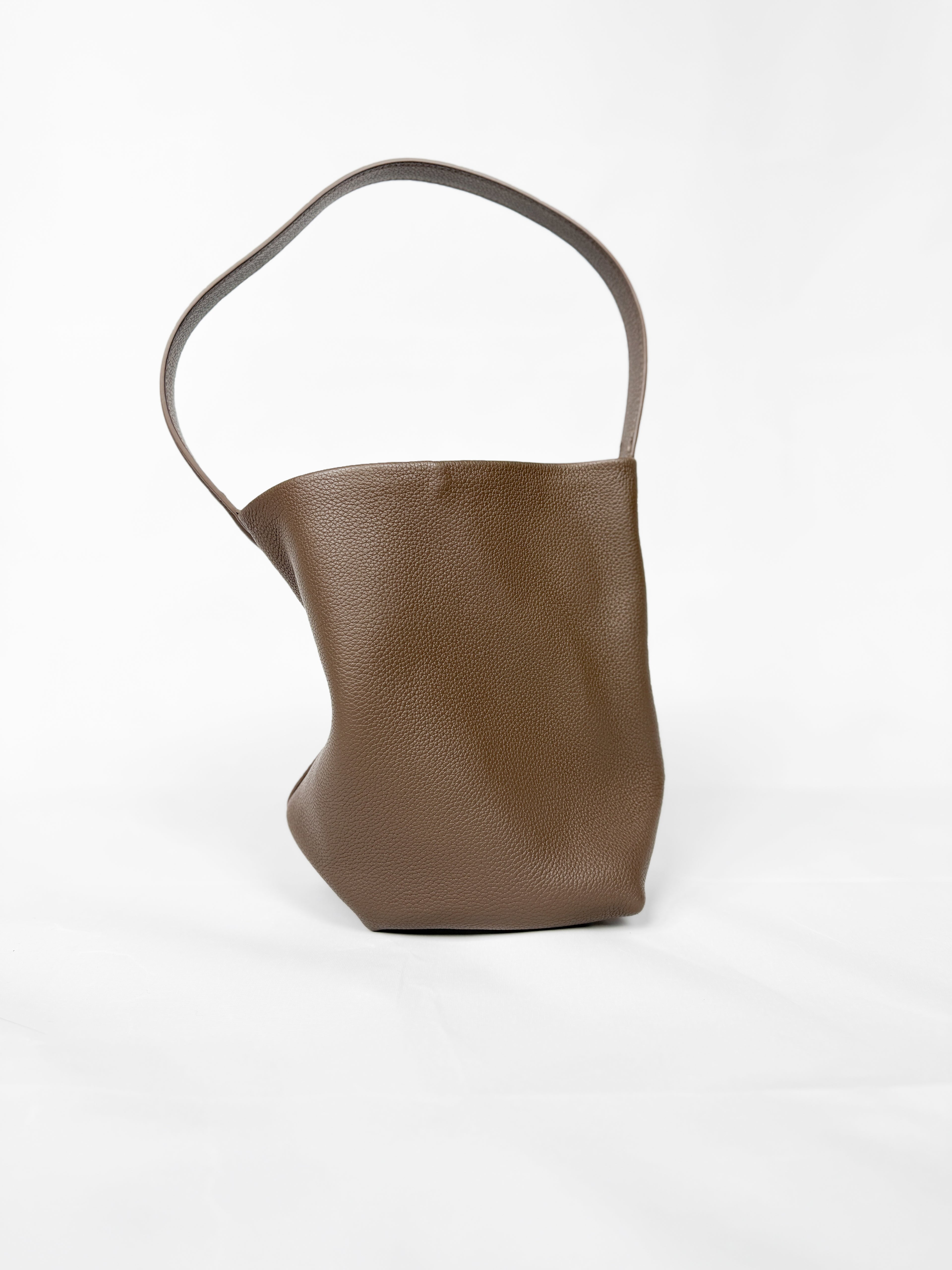 Brown leather handbag with a handle on a white background